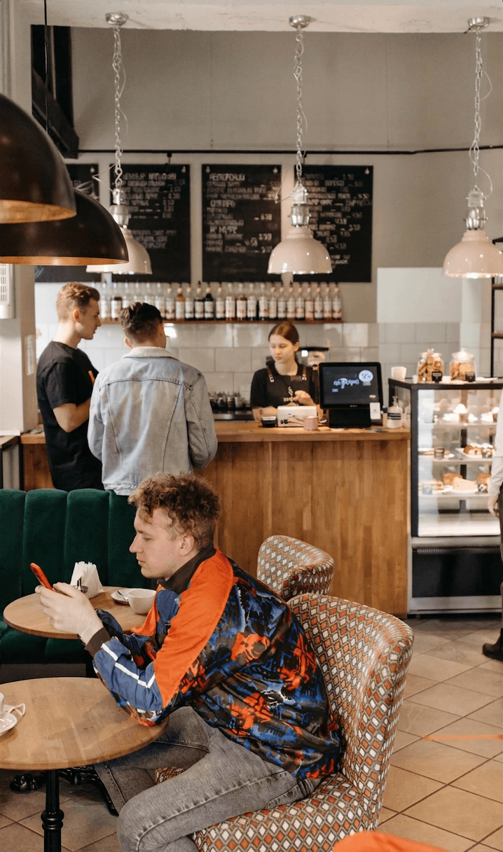 Business owner using their phone at a busy café
