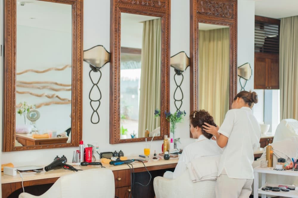 Salon interior with styling mirrors and a stylist at work