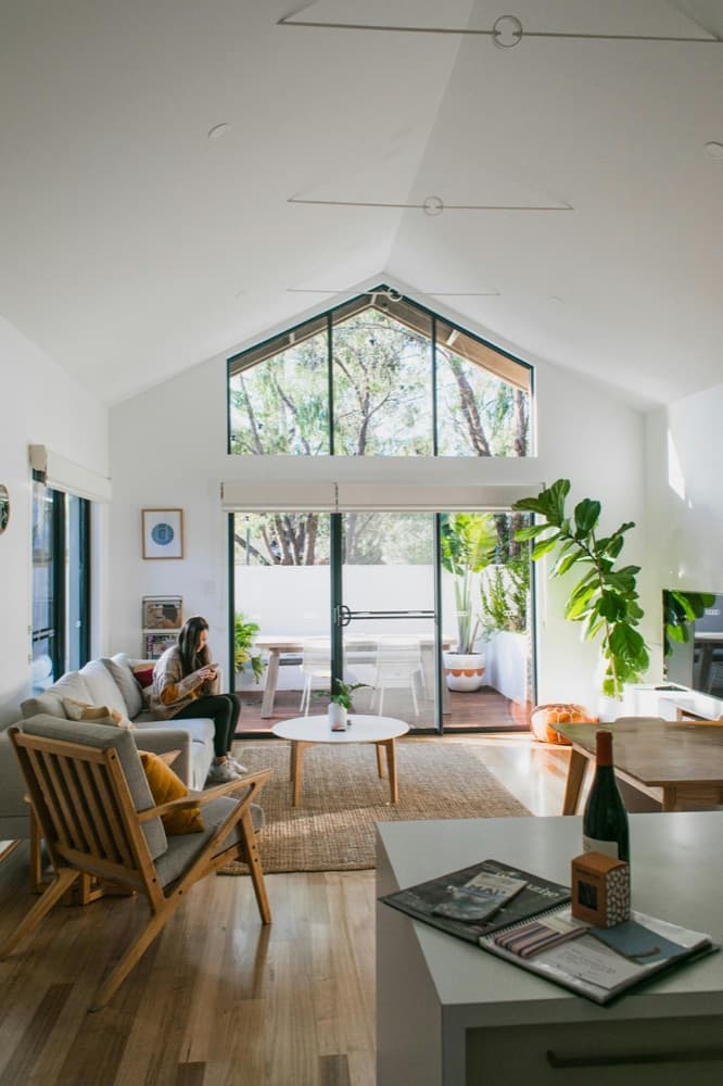 Bright short-let living room with a guest relaxing